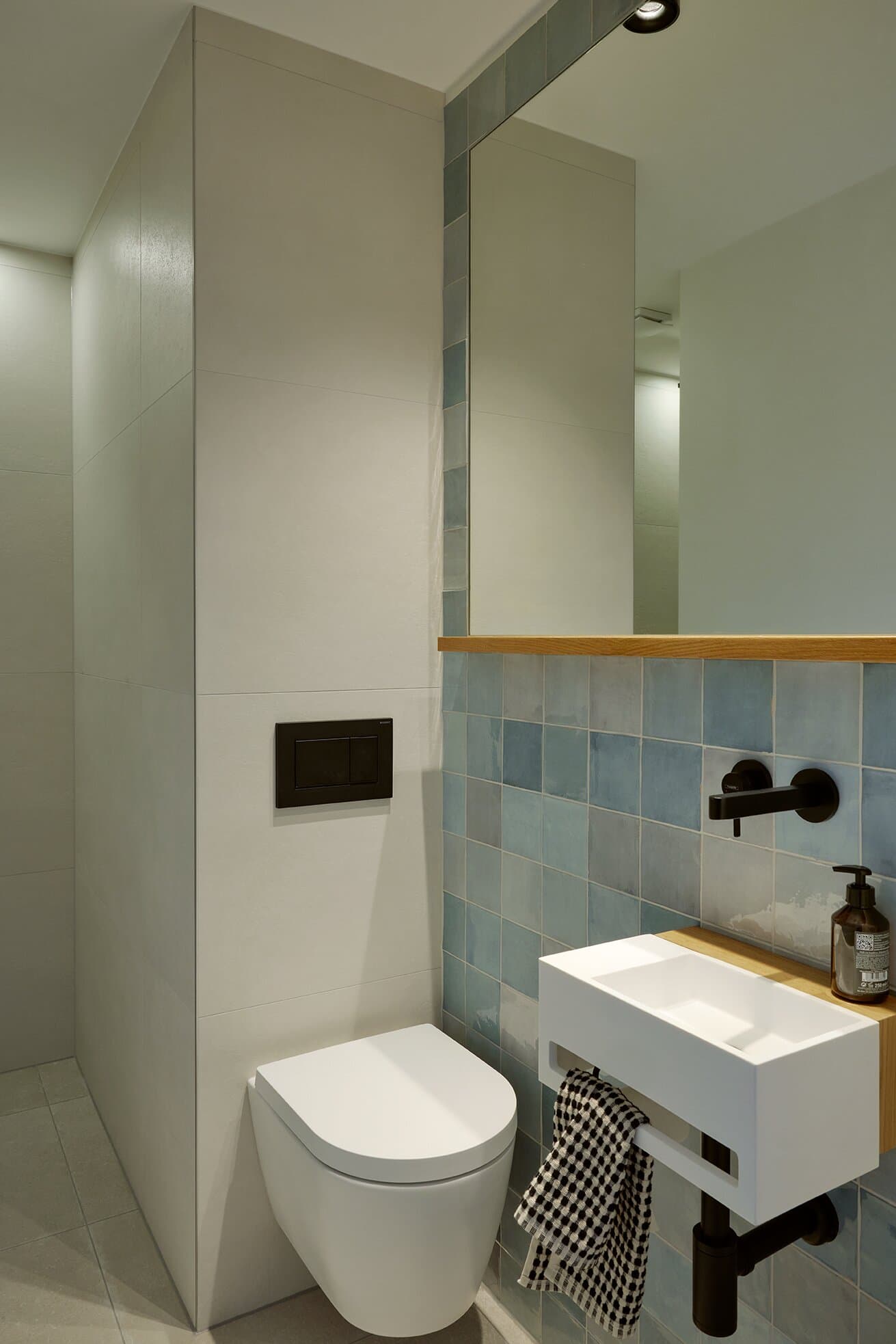 Gästebad mit Walk-in-Regendusche, weißem Wandwaschbecken und azur-blauer Zellige-Akzentwand