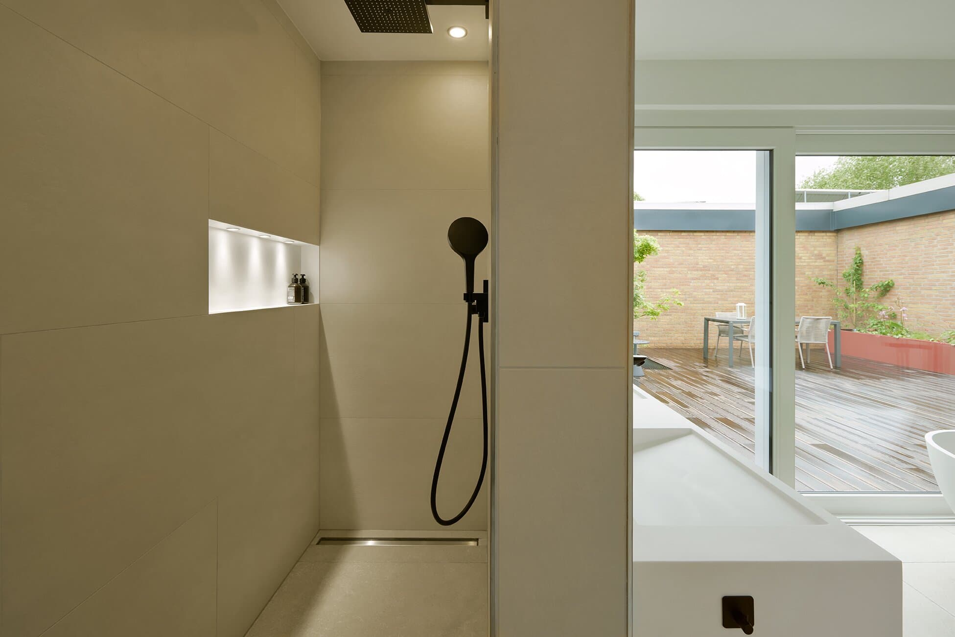 Walk-in Regendusche im Masterbad mit beleuchteter Wandnische und schwarzer Handbrause