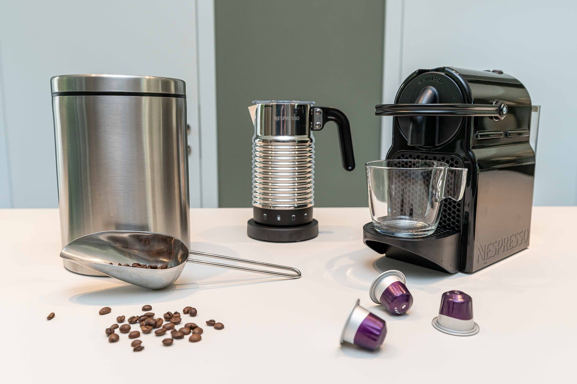 Kaffee-Station in der Küche, Nespresso-Maschine mit Kapseln, Milchaufschäumer und Edelstahldose voller Kaffeebohnen